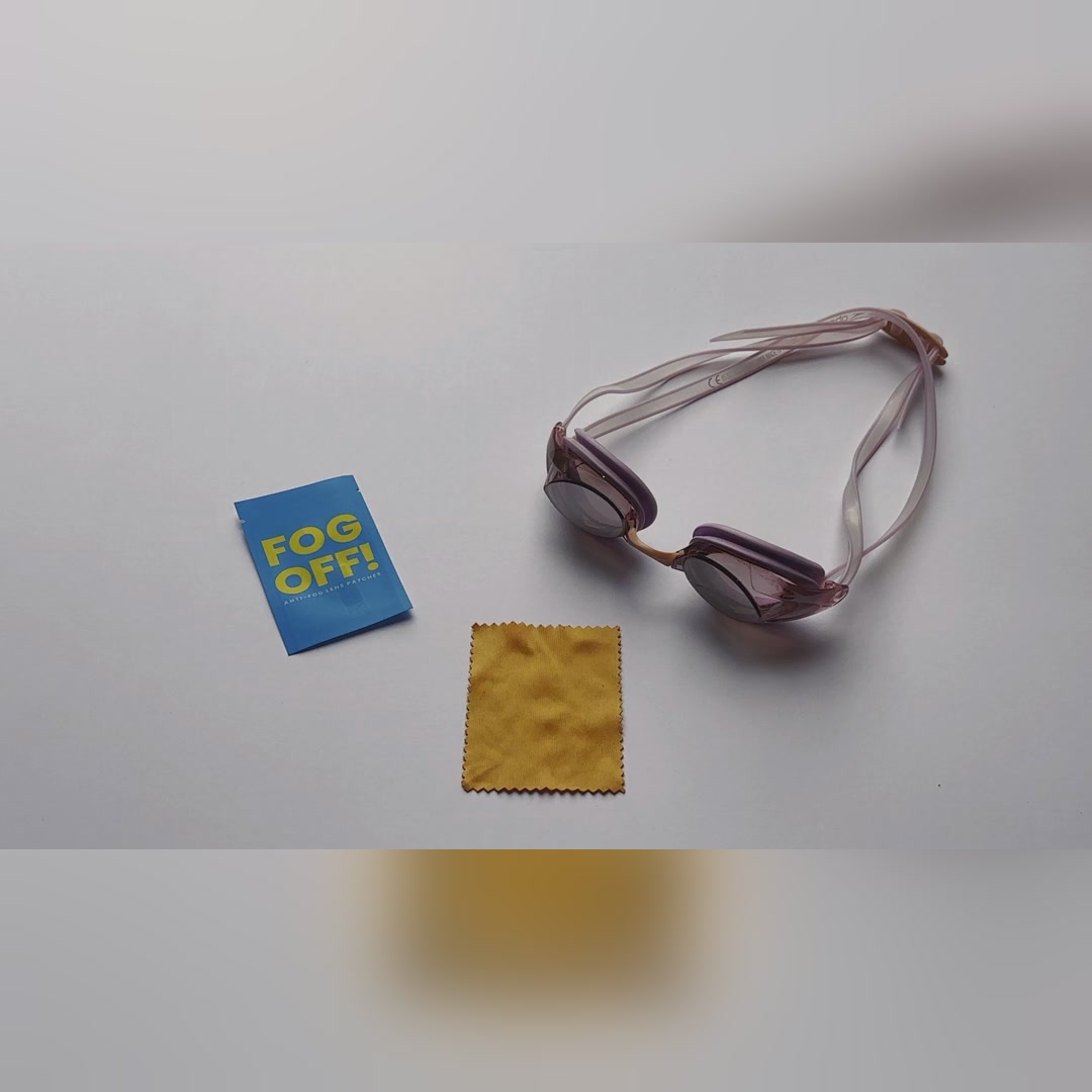 Swim goggles, a FOG OFF! anti-fog patch pack and a microfibre cloth